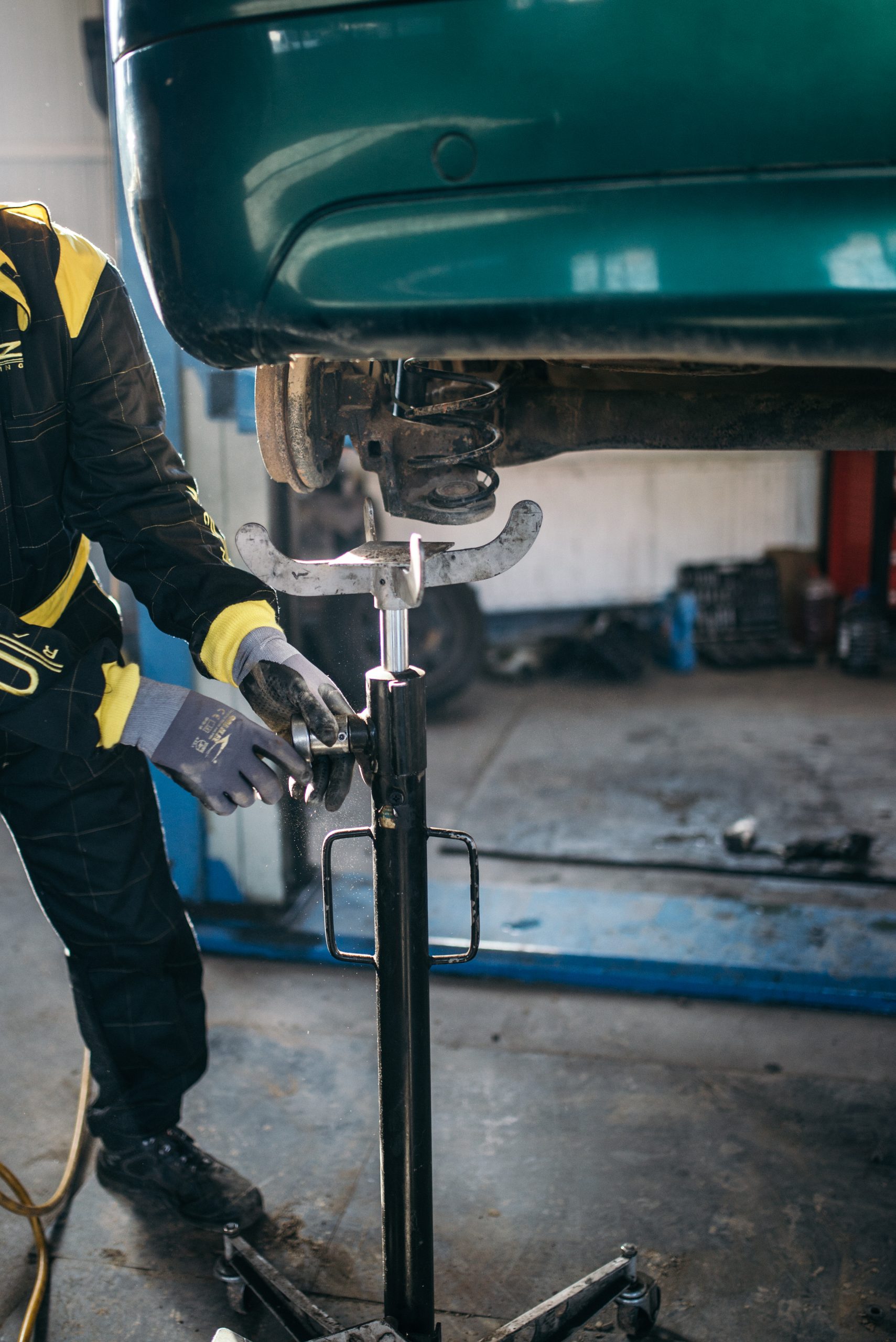 Meccanico qualificato al lavoro in officina su automobile per spese improvvise di manutenzione